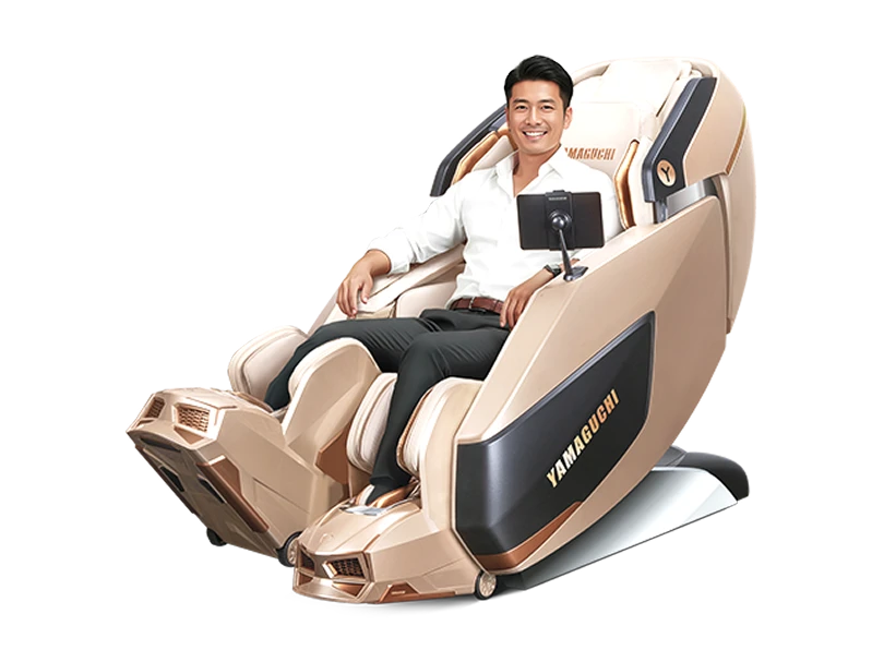 Мужчина сидит в золотом массажном кресле Yamaguchi XI, расслабляется и улыбается