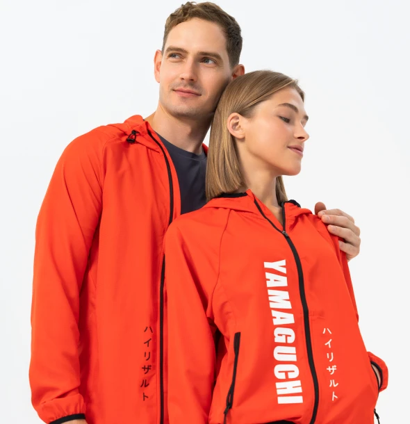 Мужчина и женщина в оранжевых спортивных костюмах Yamaguchi стоят рядом